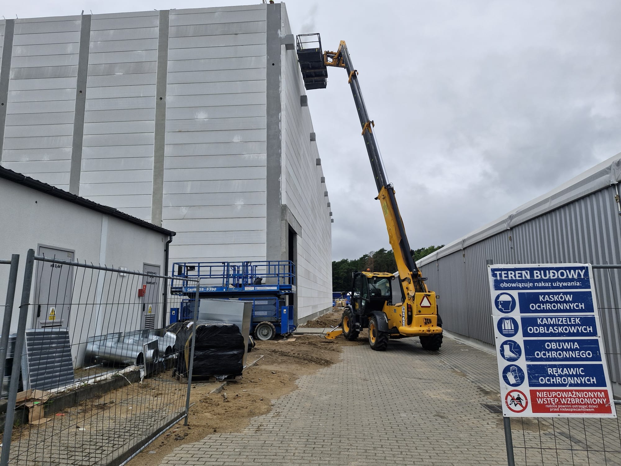 Ładowarka teleskopowa z koszem roboczym przy pracach na elewacji